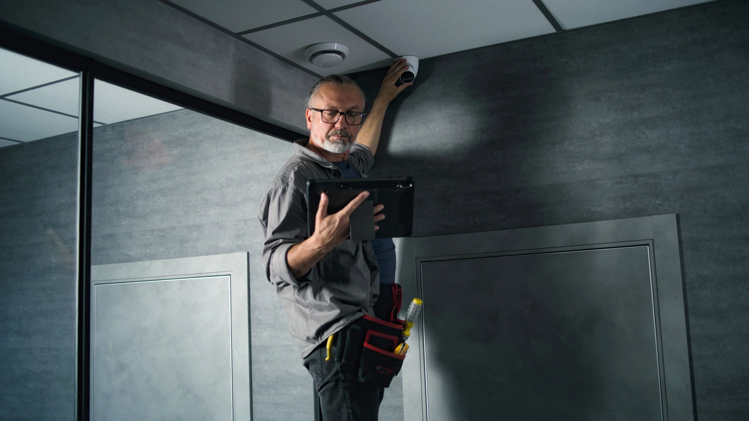 Technician installing and configuring a connected security device