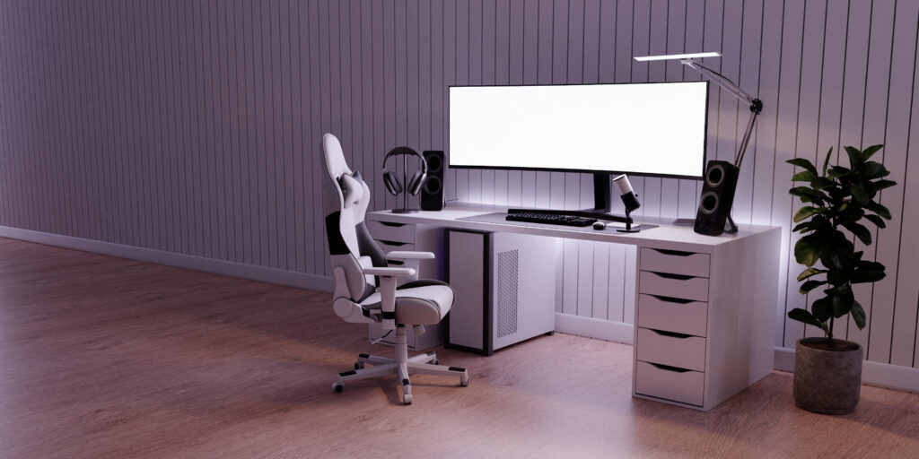 Modern home office workstation with white L-shaped desk, monitor, keyboard, ergonomic chair, and plant